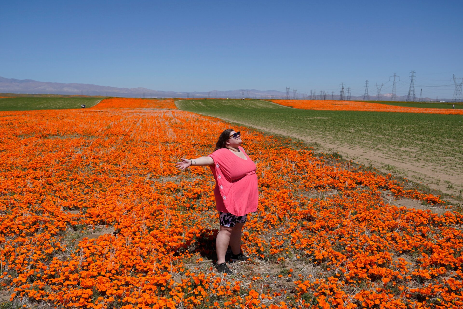 A visitor from Atlanta poses on the Antelope Valley Poppy Reserve near Lancaster, CA on April 10, 2023.
