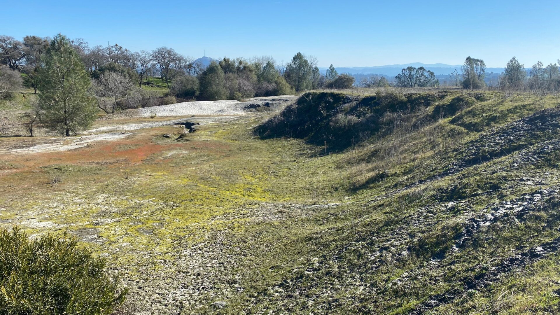 On the edge of the Tailings 4 Area of the Argonaut Mine Superfund Site, there’s an old earthen dam that was constructed out of the leftover waste and rocks dug up from the mine, to stop mine waste from flowing off the site. The dam used to be about 20 feet taller, but in the 1970s, the city dug some of it out to build roads around town.