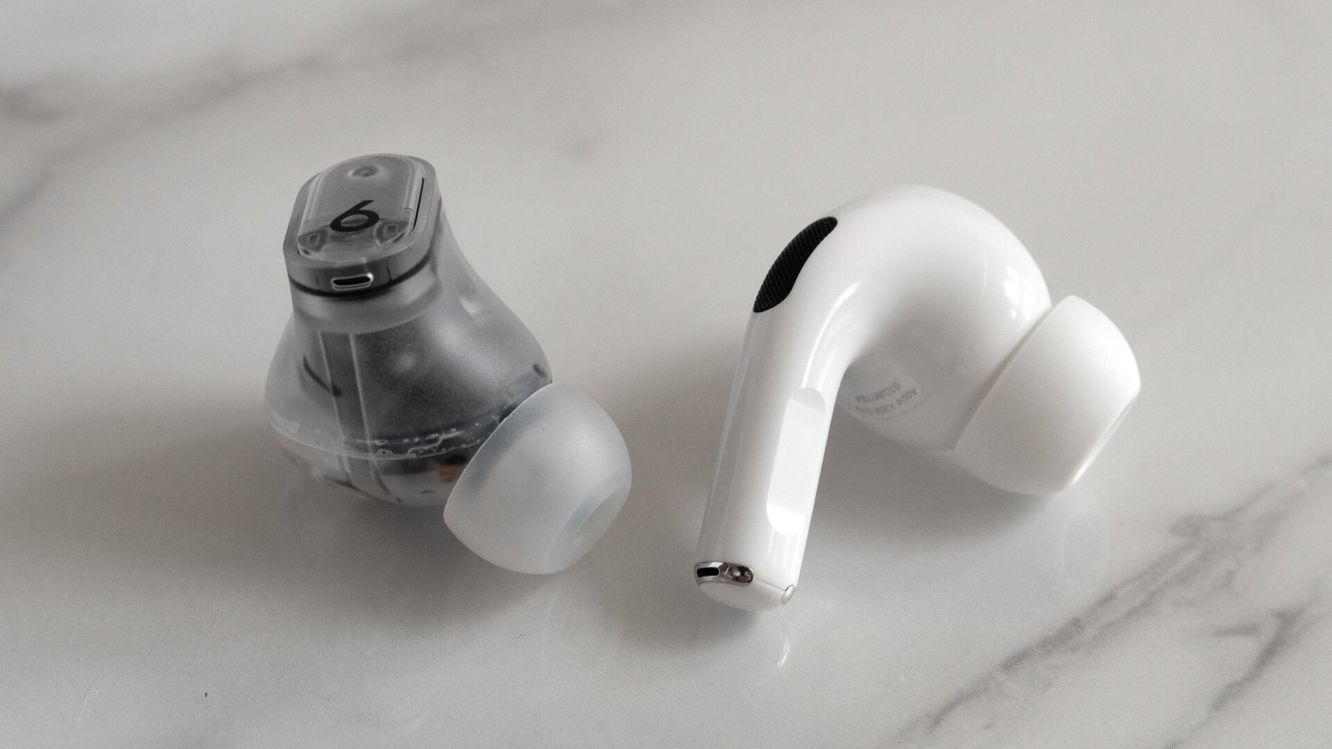 The Beats Studio Buds + (left) feature a more traditional in-ear earbud design, compared to the Apple AirPods Pro 2 (right) which house some of the electronics in a protruding stem.