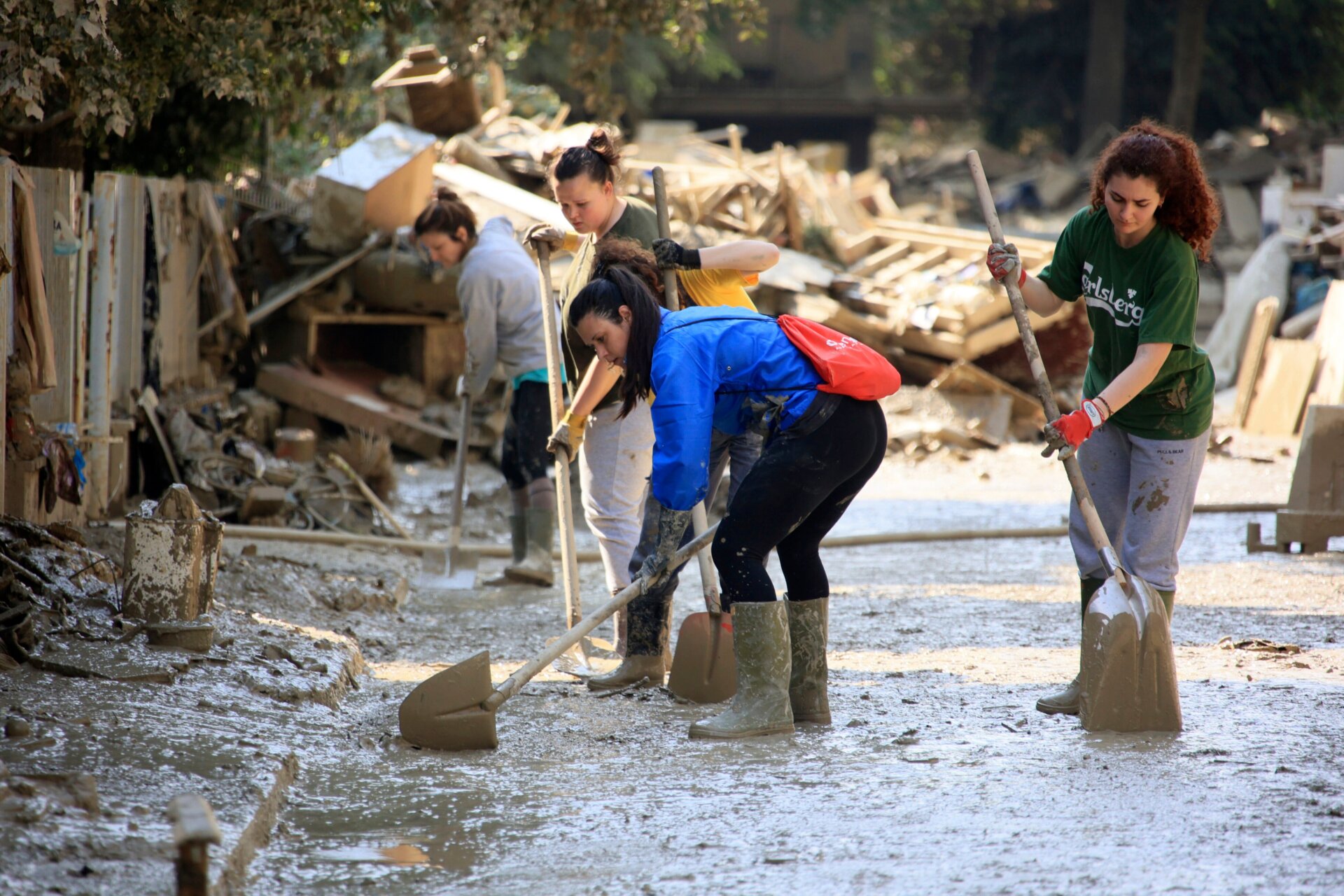 Volunteers work to clean up a street surrounded by piles of peoples’ belonging and other debris in Faenza, Italy on May 22. 
