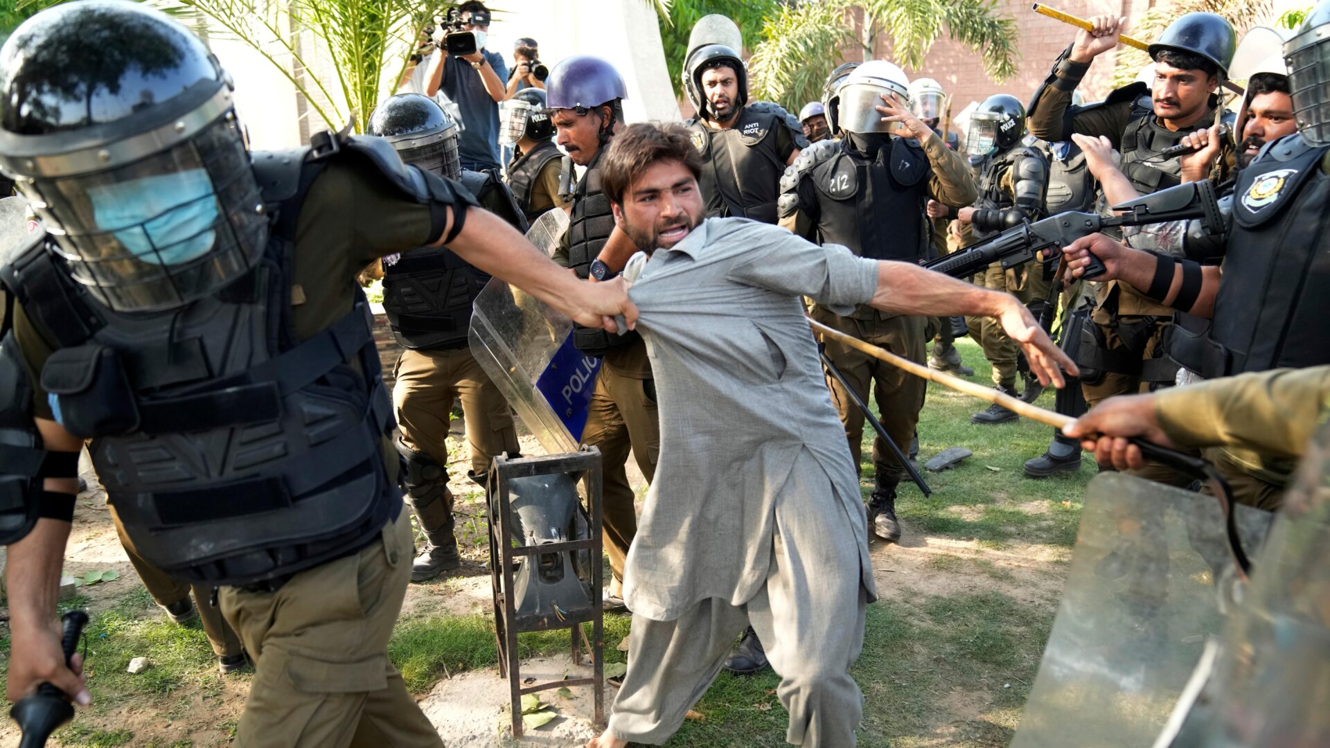 Police surround and detain a protestor on Wednesday amid mass demonstrations against the arrest of former prime minister, Imran Khan.