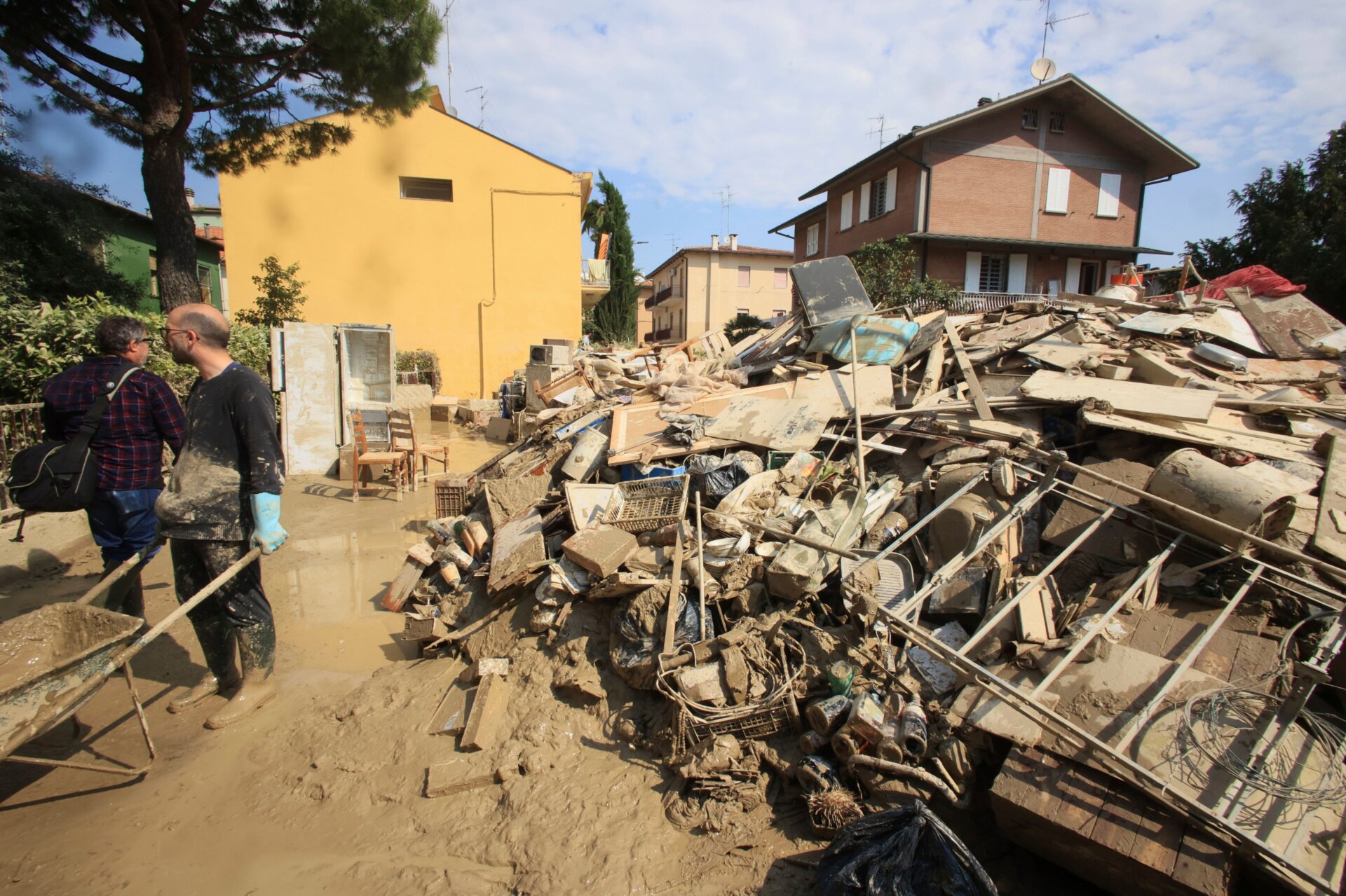Raging floodwaters dragged peoples’ belongings out of their homes. A pile of household goods, feet high, is visible beside volunteers in Faenza, Italy on May 22 working to clean up mud. 
