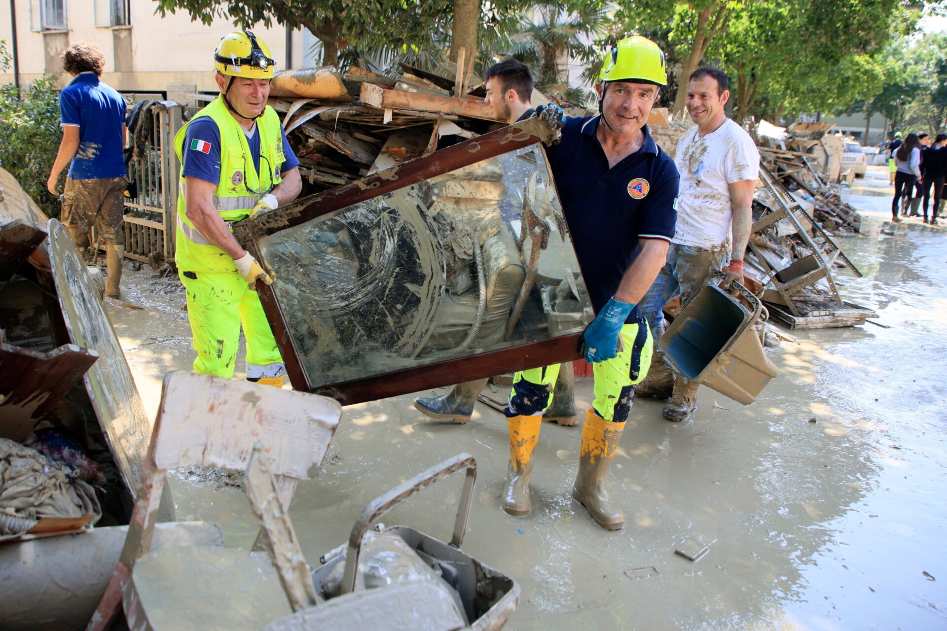 Civil protection members and others work to clear debris in Faenza, Italy on May 22 in the aftermath of flooding. 