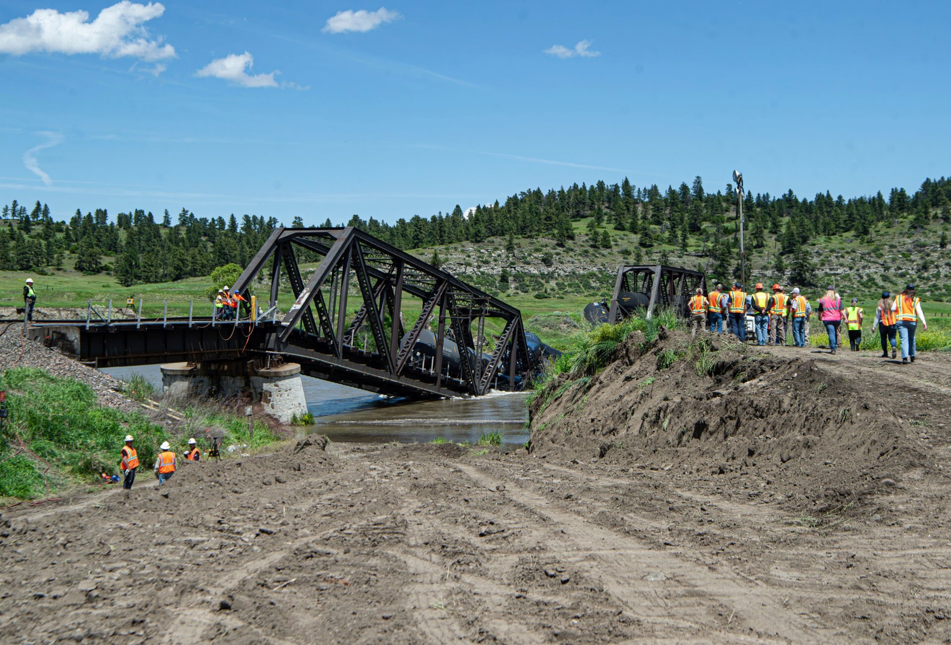 Crews work the site of a railroad bridge collapse on the Yellowstone River near Reed Point, Sunday afternoon, June 25, 2023, in Columbus, Montana.