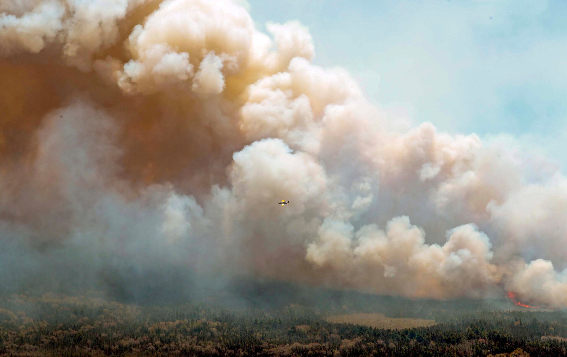 n this aerial image, an aircraft, center, flies near a wildfire burning near Barrington Lake in Nova Scotia, on May 31, 2023. 