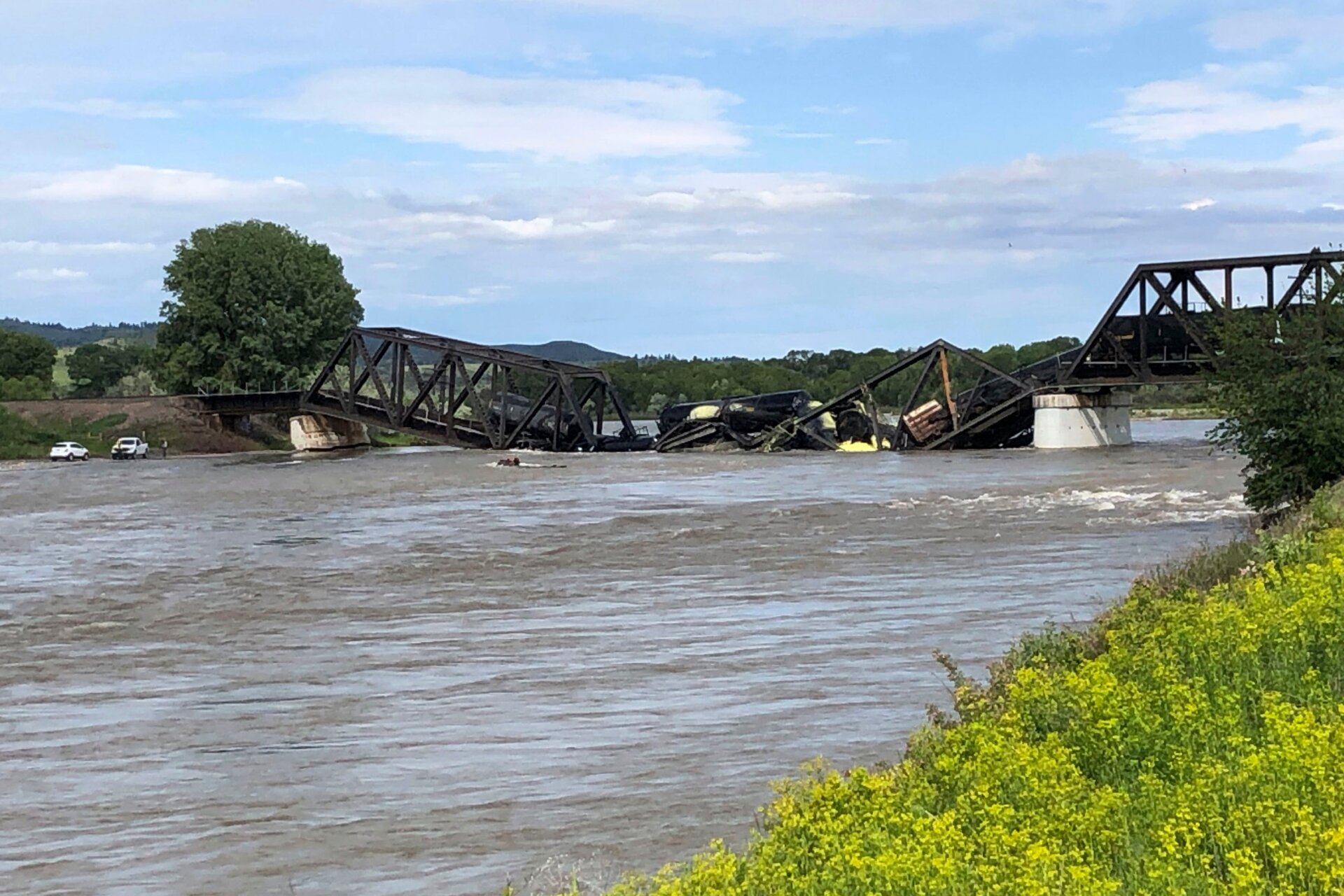 Several train cars are immersed in the Yellowstone River after a bridge collapse near Columbus, Montana, on Saturday, June 24, 2023.