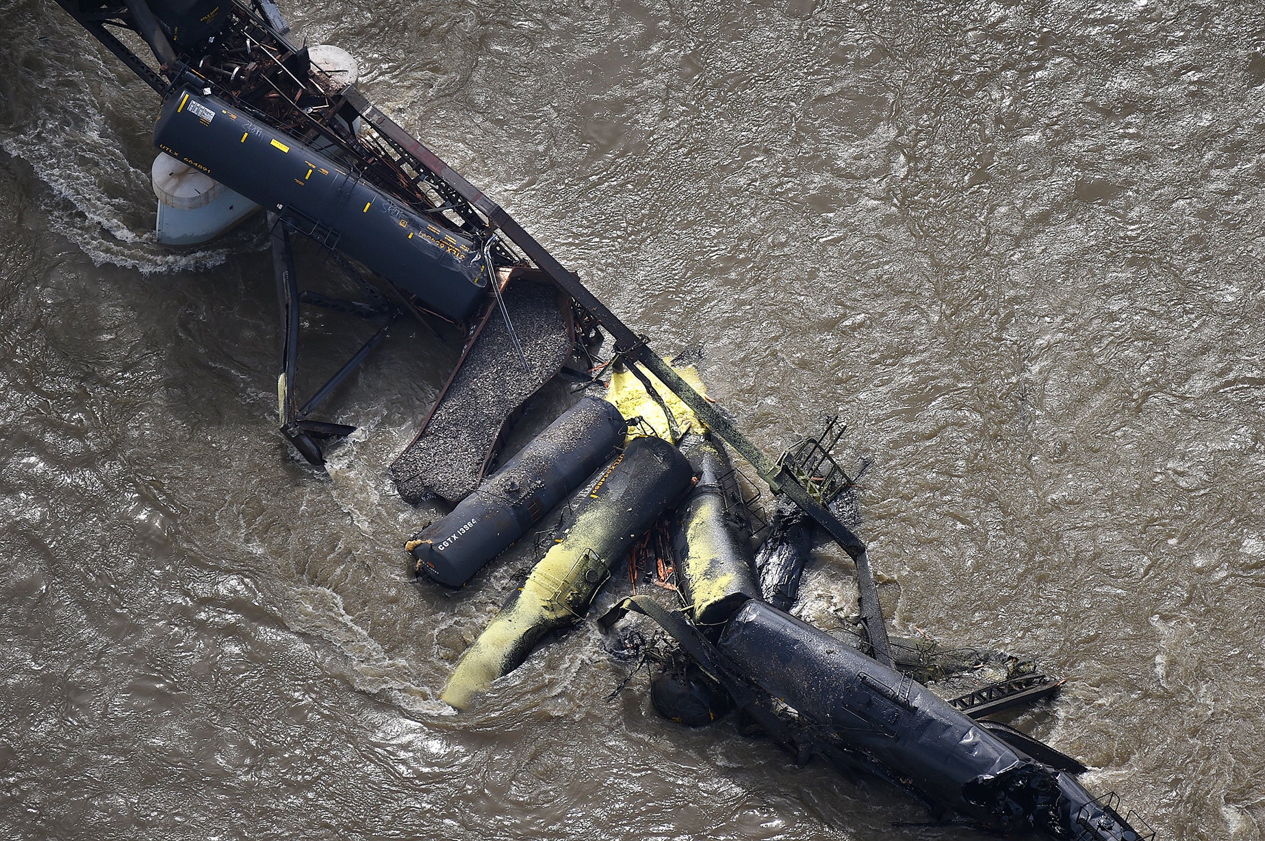 Portions of a freight train are seen in the Yellowstone River after an overnight railroad bridge collapse, near Columbus, Montana, on Saturday, June 24, 2023.
