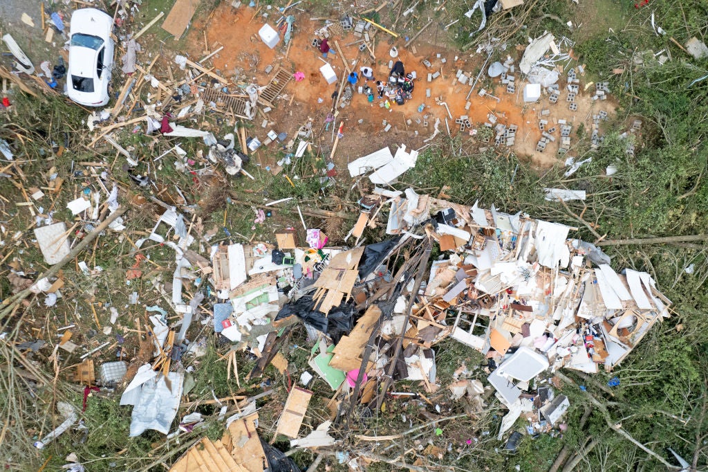 In this aerial view, residents attempt to salvage what they can from a destroyed dwelling after a tornado struck off Country Road 16, on June 19, 2023 in Louin, Mississippi.