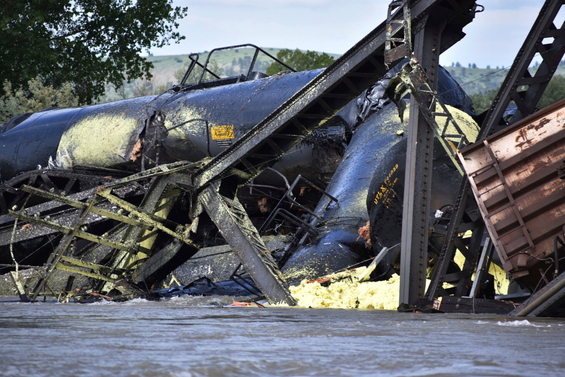 Several train cars are immersed in the Yellowstone River after a bridge collapse near Columbus, Montana, on Saturday, June 24, 2023.