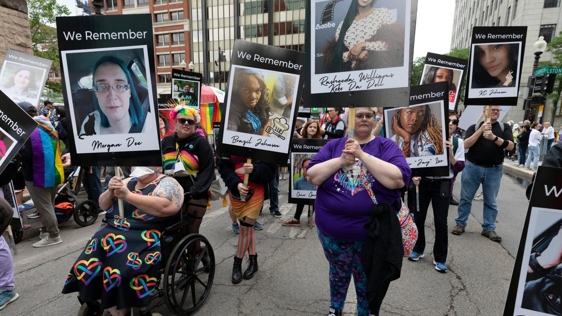 Marchers in the Boston Pride Parade held up photos memorializing members of the transgender community killed due to trans hate.