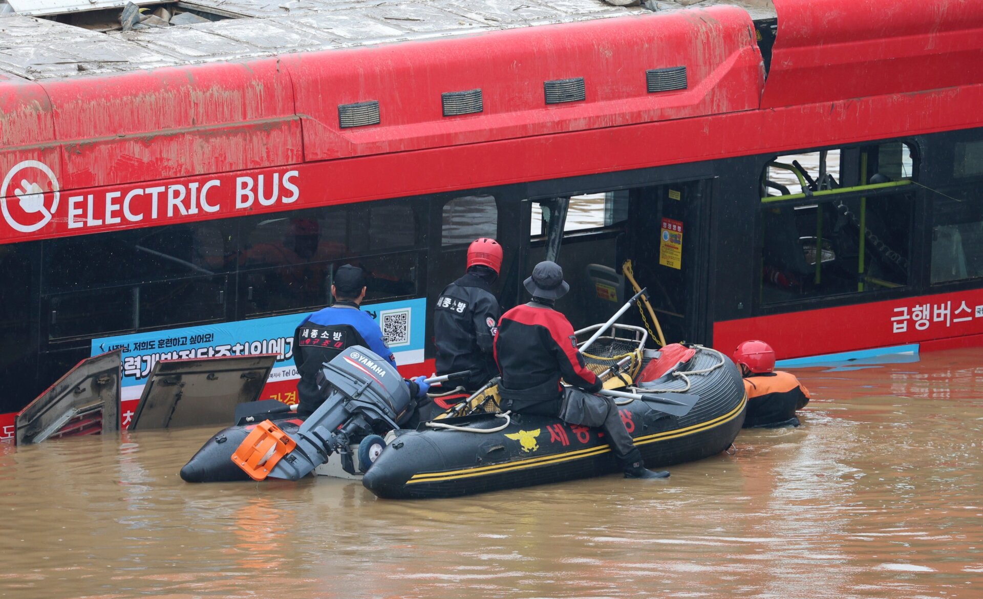Rescuers conduct a search operation along a road submerged by floodwaters leading to an underground tunnel in Cheongju, South Korea, on July 16, 2023.