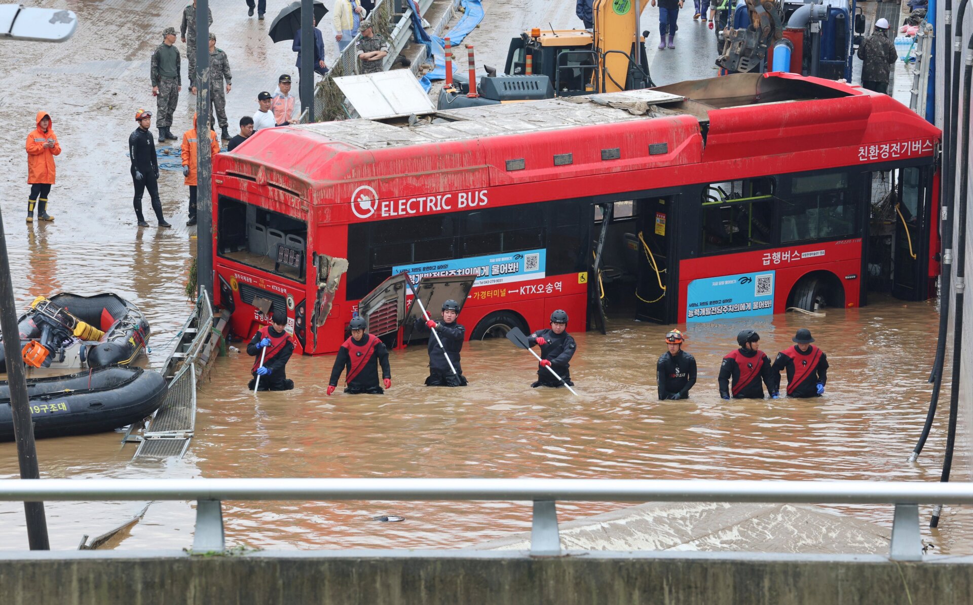 Rescuers search for survivors along a road submerged by floodwaters leading to an underground tunnel in Cheongju, South Korea, Sunday, July 16, 2023.
