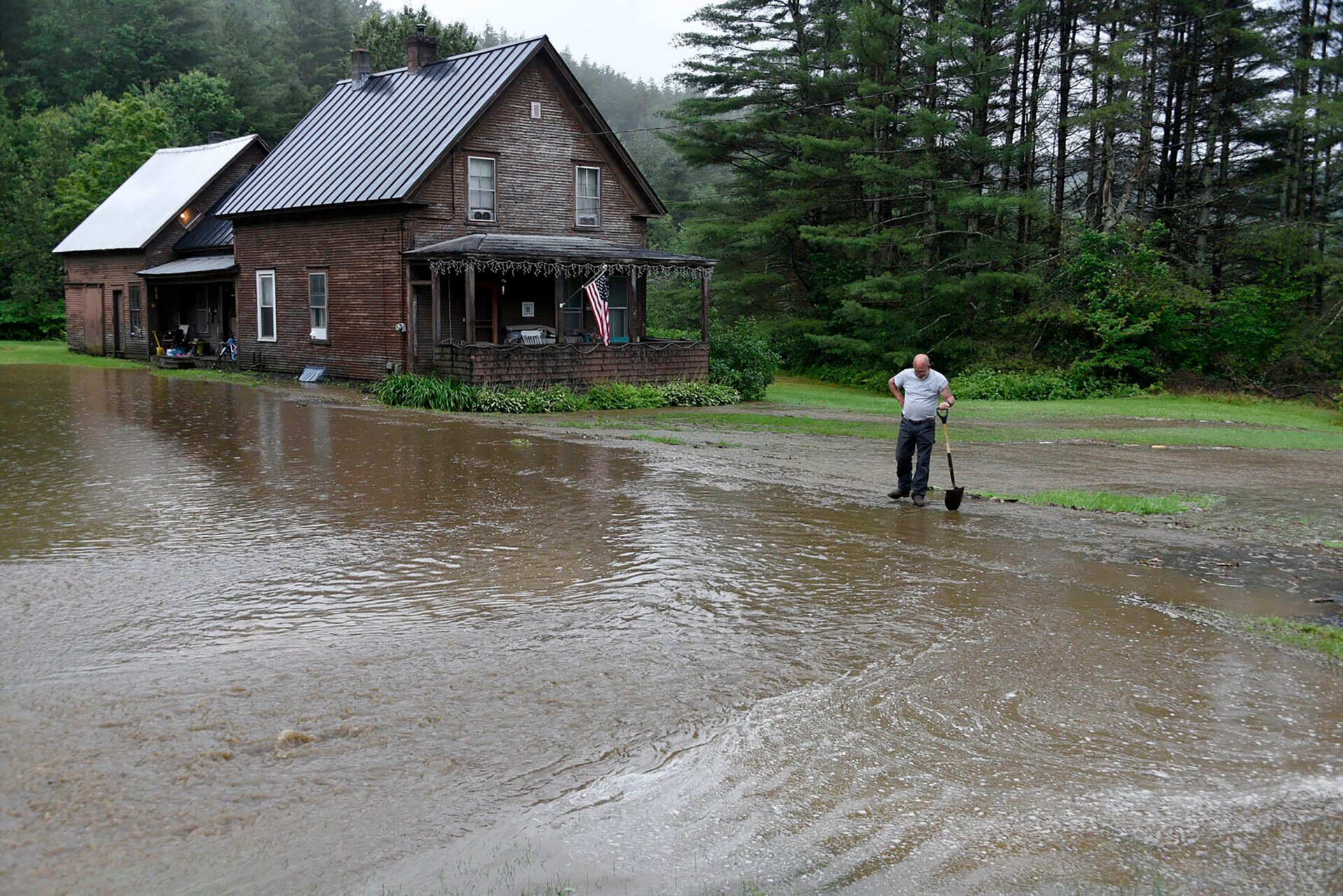 Shawn McManis checks rising water outside his cousin’s home in Worcester, Vt. on Sunday, July 9, 2023.