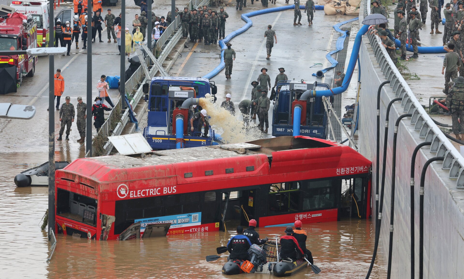 Rescuers search for survivors along a road submerged by floodwaters leading to an underground tunnel in Cheongju, South Korea, on July 16, 2023. 