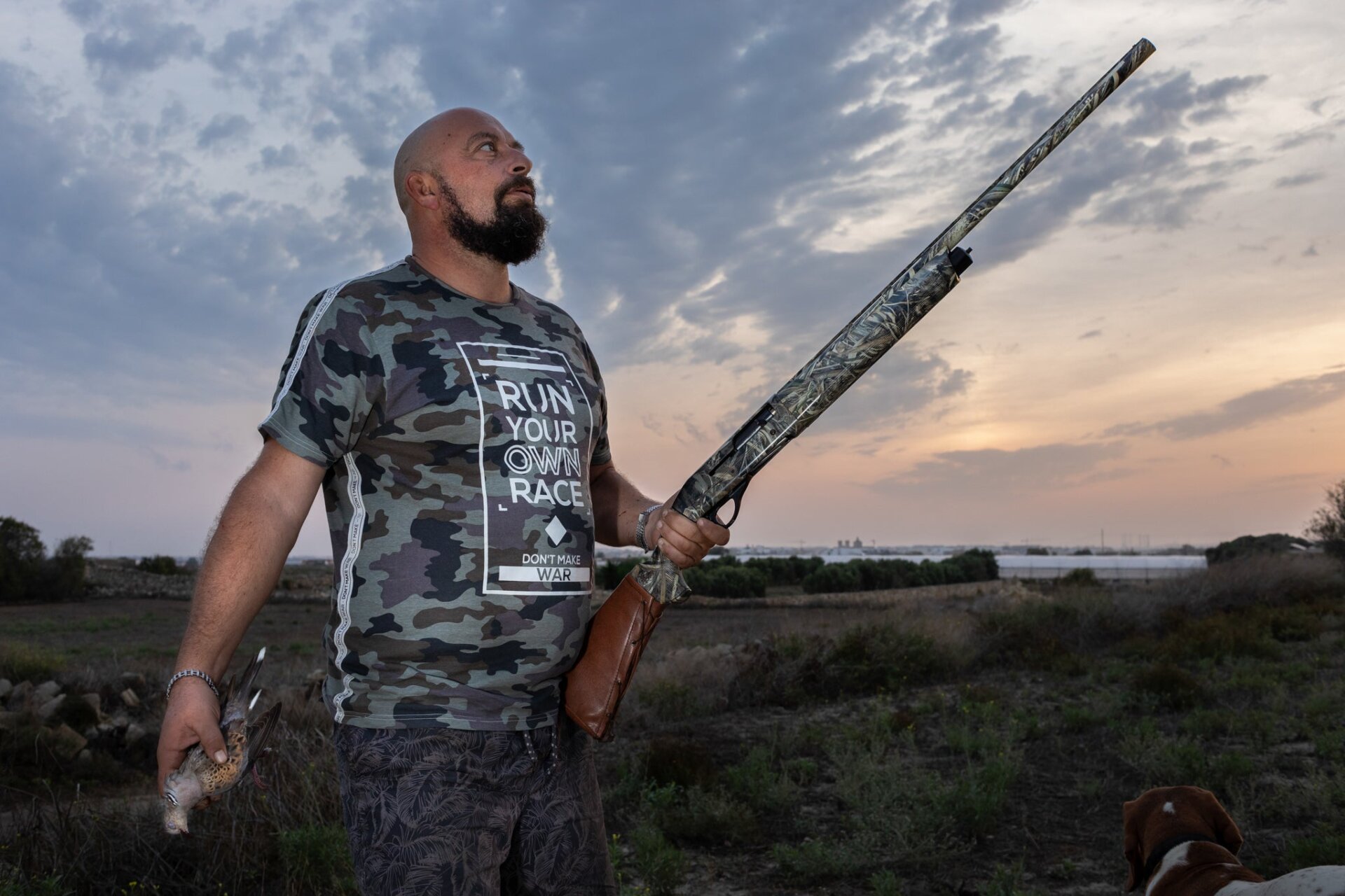 A hunter holding his quarry, a European turtle dove.