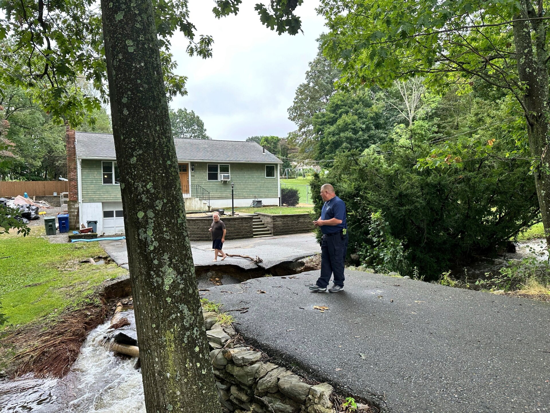 Home owner John Schuller assesses flood damage to the road leading to his house in Leominster, Massachusetts on September 12, 2023.