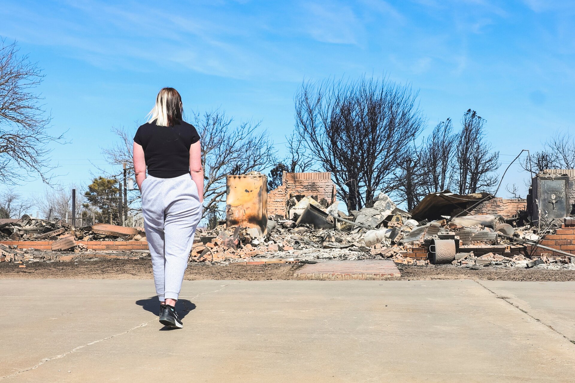 Bailey Barnes examines what is left of her parents’, Brent and Rachel  Clapp, home on Wednesday, Feb. 28, 2024, in Canadian, Texas.