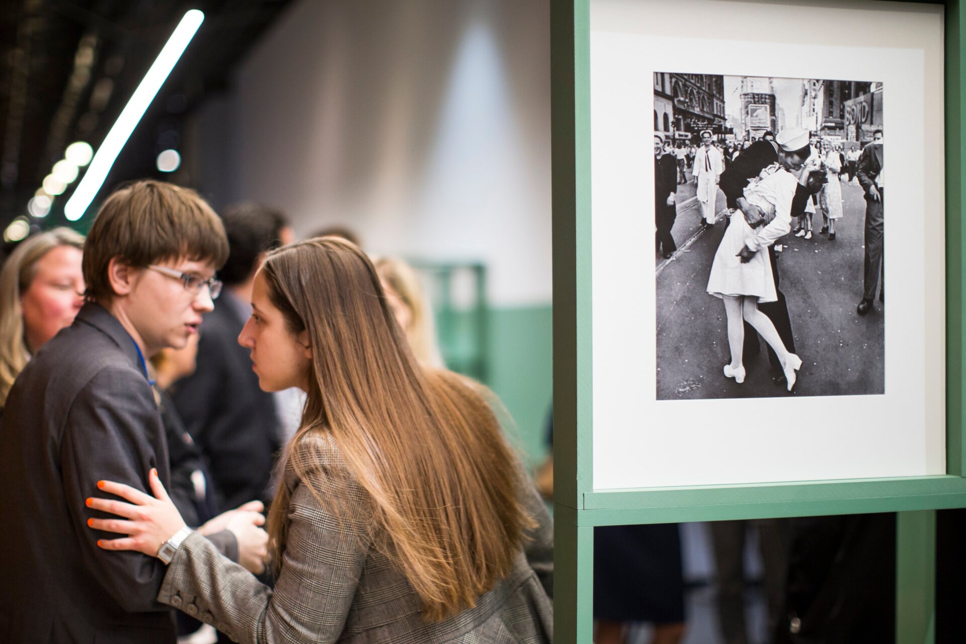 People speak next to a famous photograph taken by Alfred Eisenstaedt of a  sailor kissing a nurse in New York’s Times Square on V-J Day, right, as  they visit the exhibition of German-American Life magazine  photographer Alfred Eisenstaedt at Moscow’s Jewish Museum and Tolerance  Center in Moscow, Russia, Tuesday, April 14, 2015.