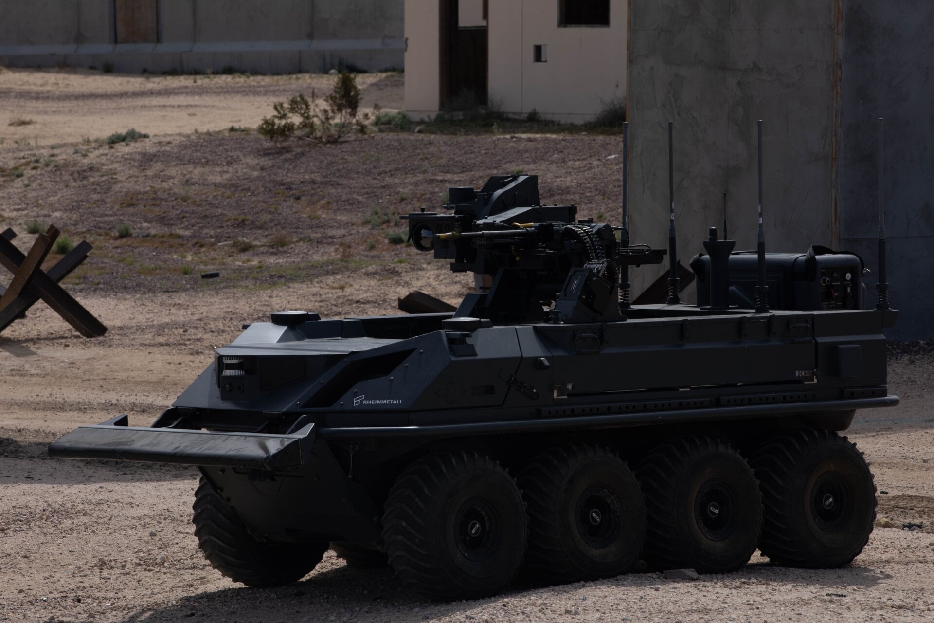 A British unmanned, eight-wheeled, all-terrain transport vehicle armed  with an autonomous weapon system by the U.K. Experimentation and Trails  Group provides support to dismounted Soldiers in an urban environment as  part of a human integration experiment at Fort Irwin, Calif, March 11,  2024.