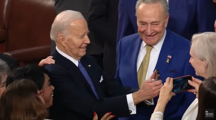 Biden takes someone’s phone, flips the camera around, and takes a selfie in front of the nation.