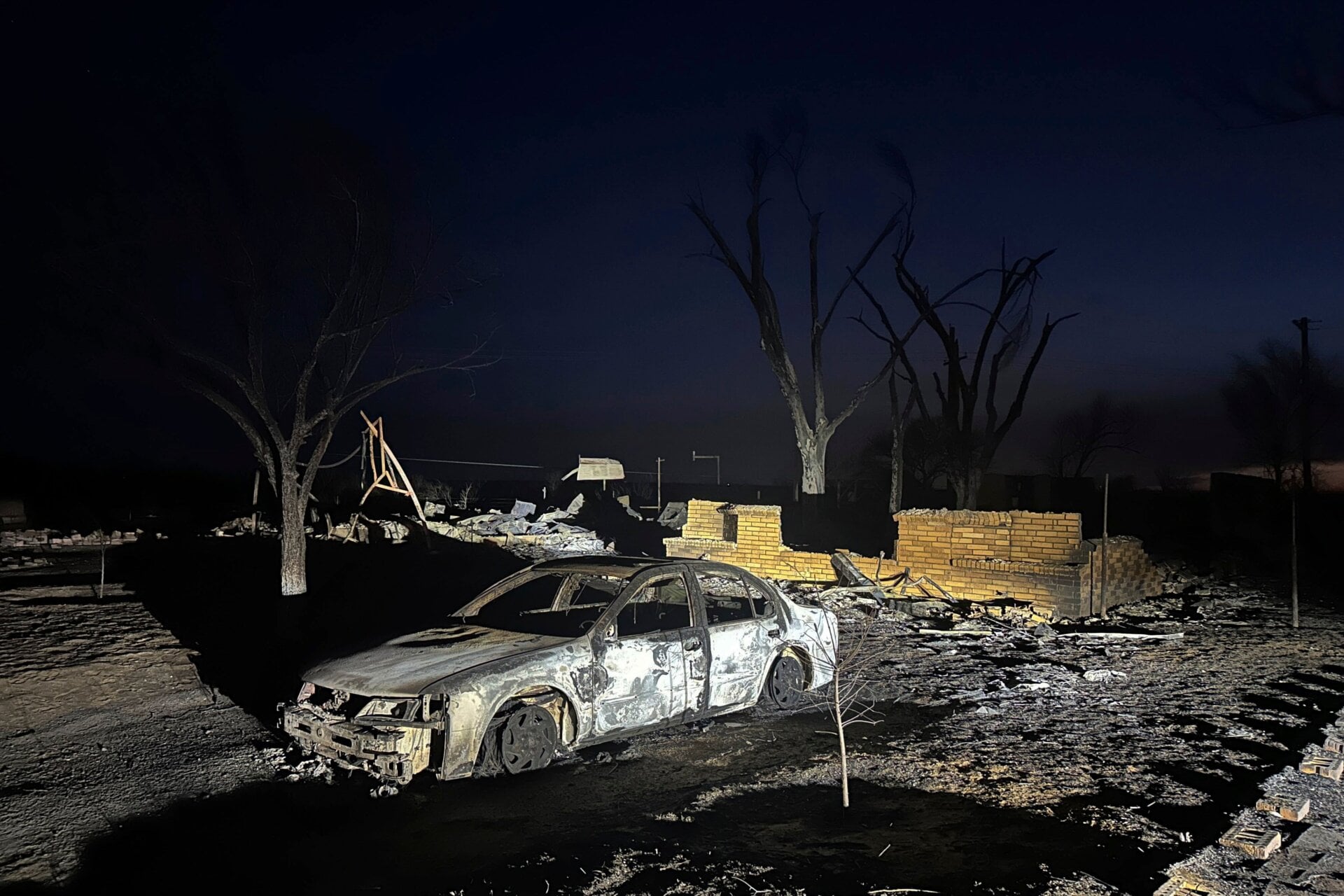A charred vehicle sits near the ruins of a home after the property was  burned by the Smokehouse Creek Fire, Wednesday, Feb. 28, 2024, in  Fritch, Texas.