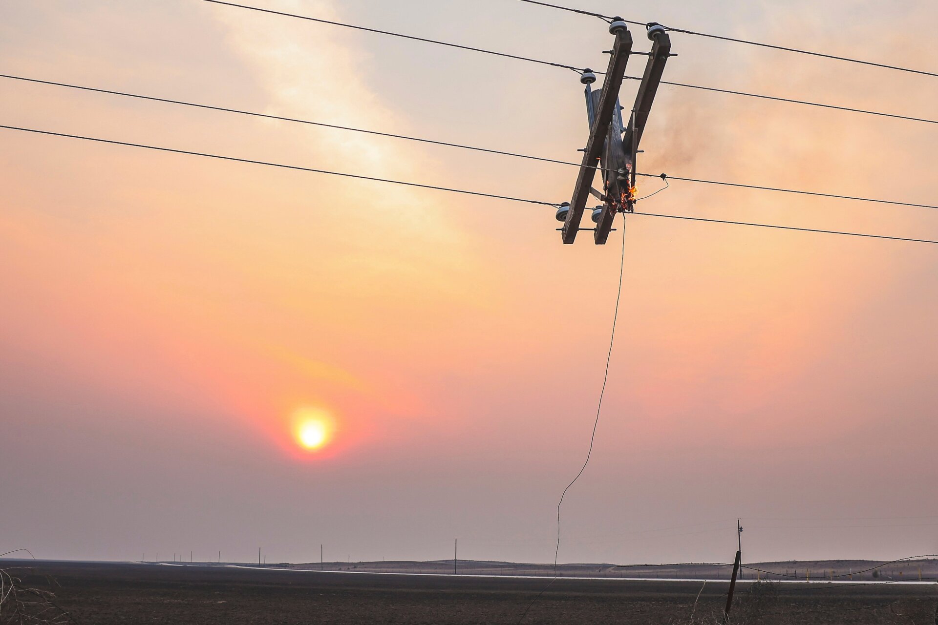 A telephone pole burns from the Smokehouse Creek Fire as the sun sets, Wednesday, Feb. 28, 2024, in Canadian, Texas.