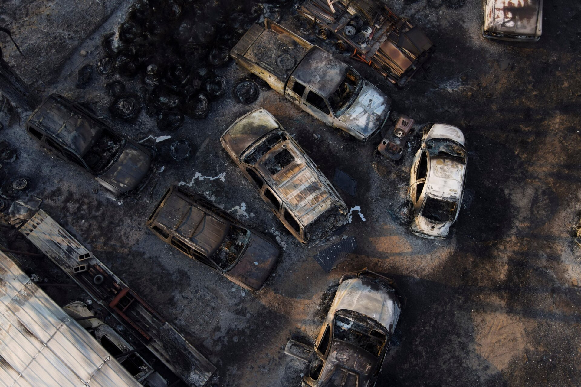 Charred vehicles sit at an auto body shop after the property was burned  by the Smokehouse Creek Fire, Wednesday, Feb. 28, 2024, in Canadian,  Texas.