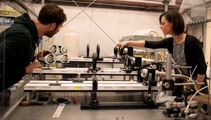 Naval Surface Warfare Center Dahlgren Division (NSWCDD) scientists Chris  Von Hohenleiten and Emily Martin prepare for a laser lethality test by  ensuring the optics are aligned correctly in April 2017. 