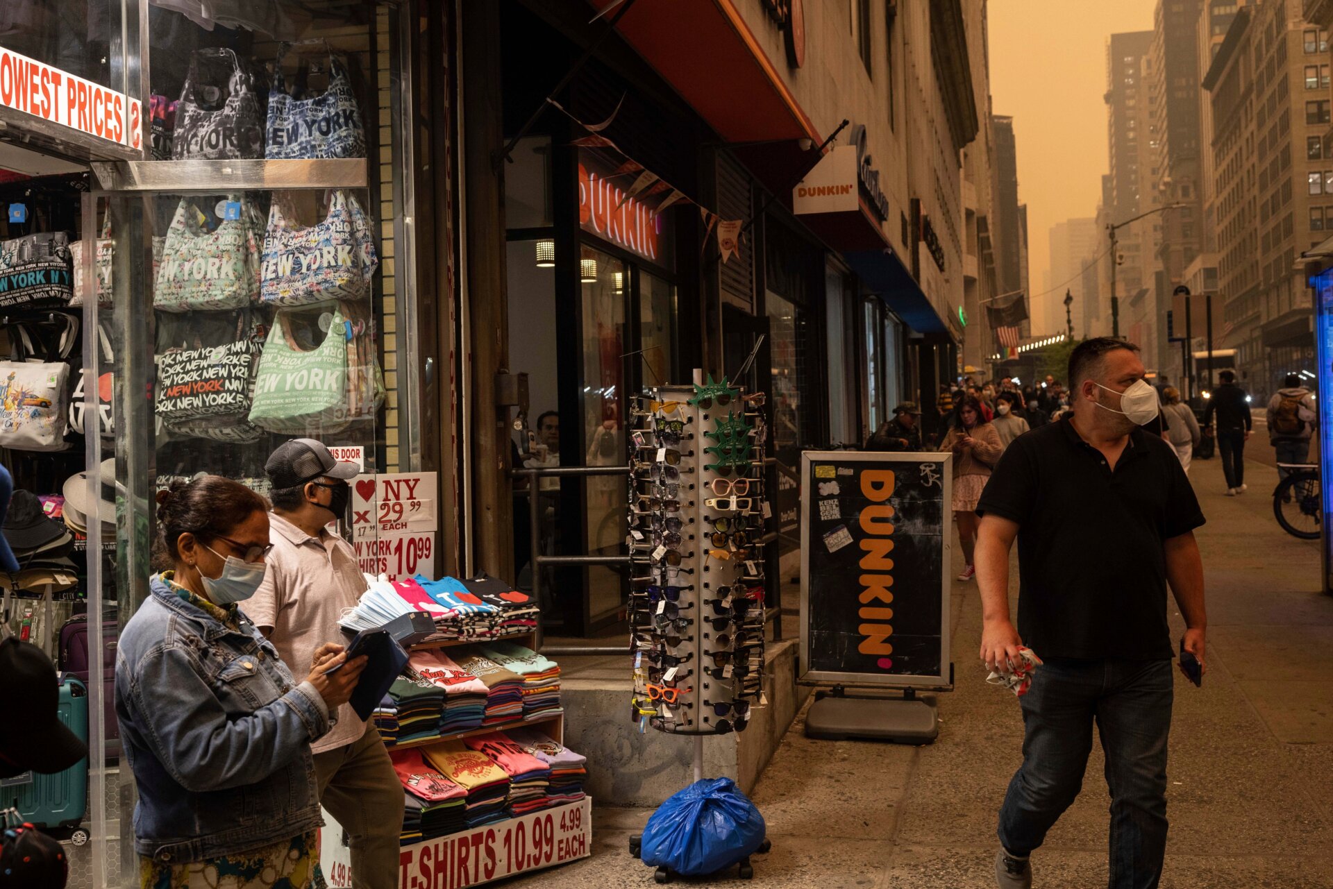 A person sells face masks outside a souvenir store in New York on Wednesday, June. 7, 2023 as wildfire smoke engulfs the city.