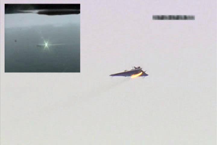 A still image from video shows a split-screen view of the Laser Weapon  System (LaWS), upper left, striking a remote-controlled target aircraft in 2012.