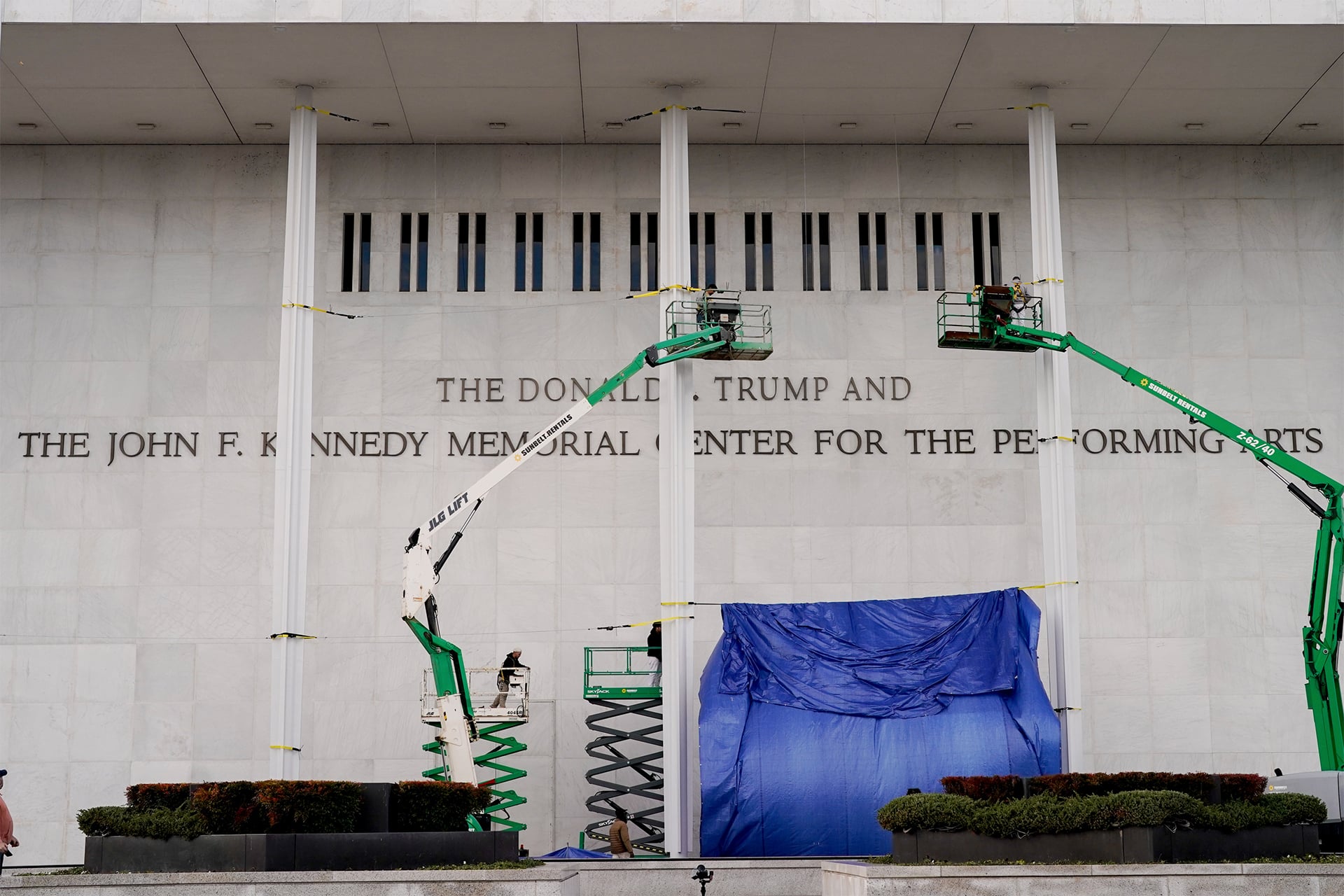 Photo of workers adding Donald Trump's name to the Kennedy Center.