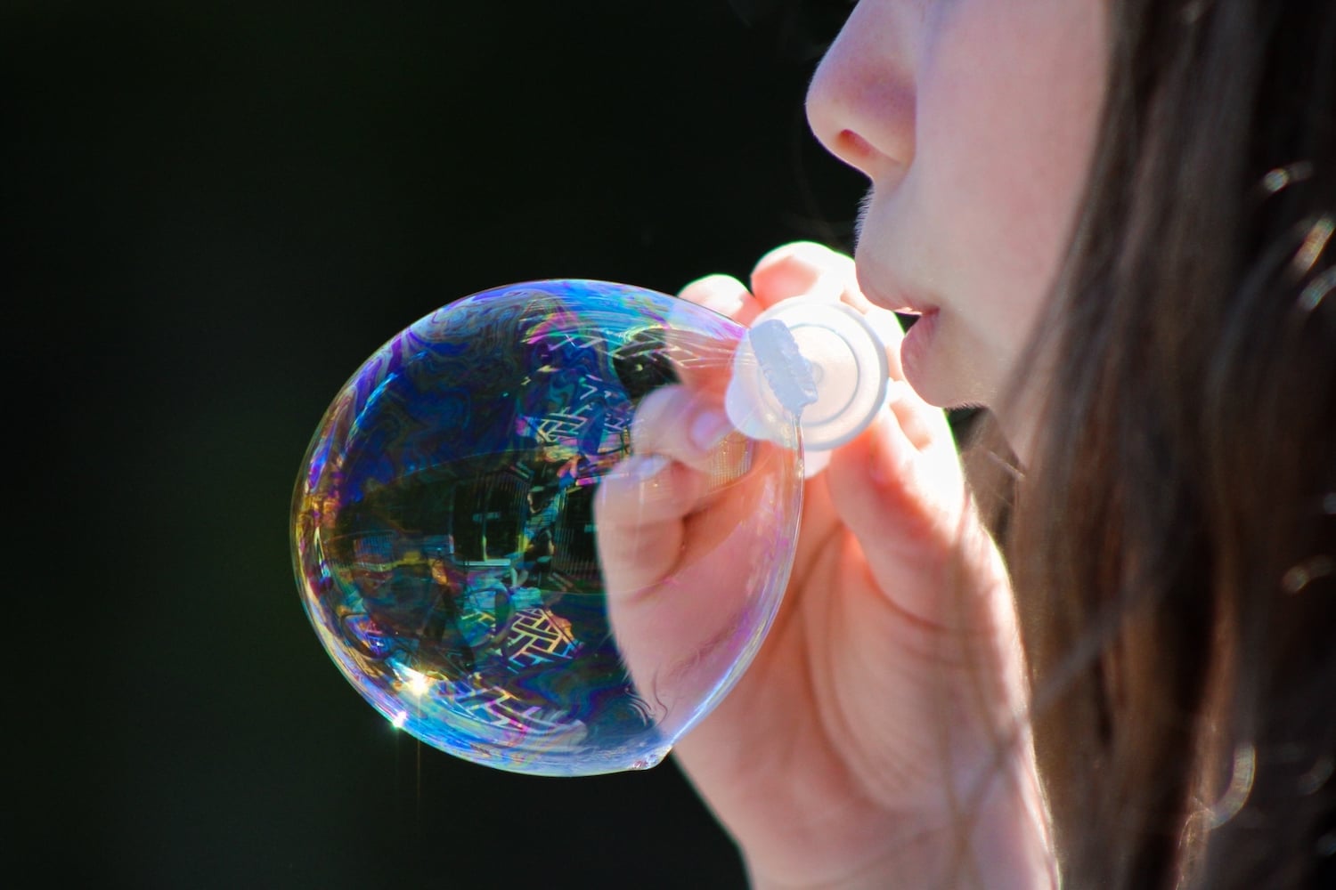 A young girl blowing a bubble