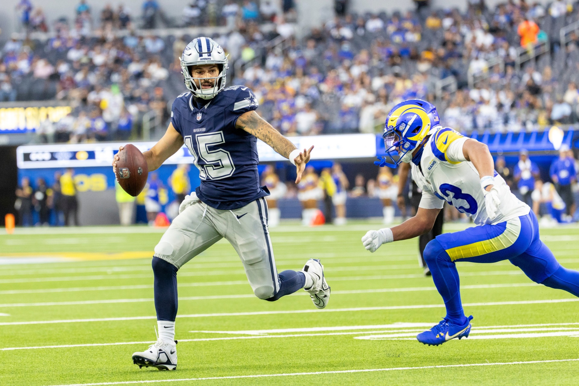 Cowboys quarterback Will Grier runs Rams safety Nate Valcarcel to score a touchdown during an NFL preseason football game at SoFi Stadium in Inglewood, California