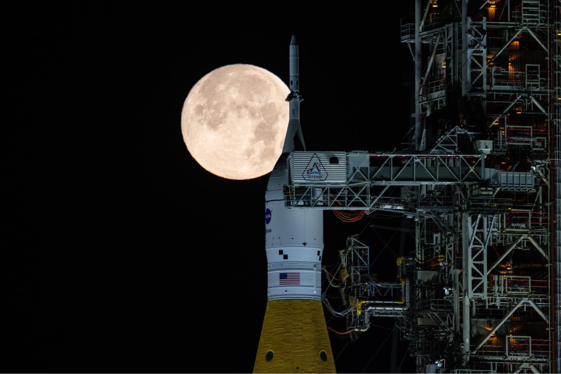 A full Moon shines over NASA’s SLS (Space Launch System) rocket and Orion spacecraft, stacked atop the mobile launcher in the early hours of February 1, 2026