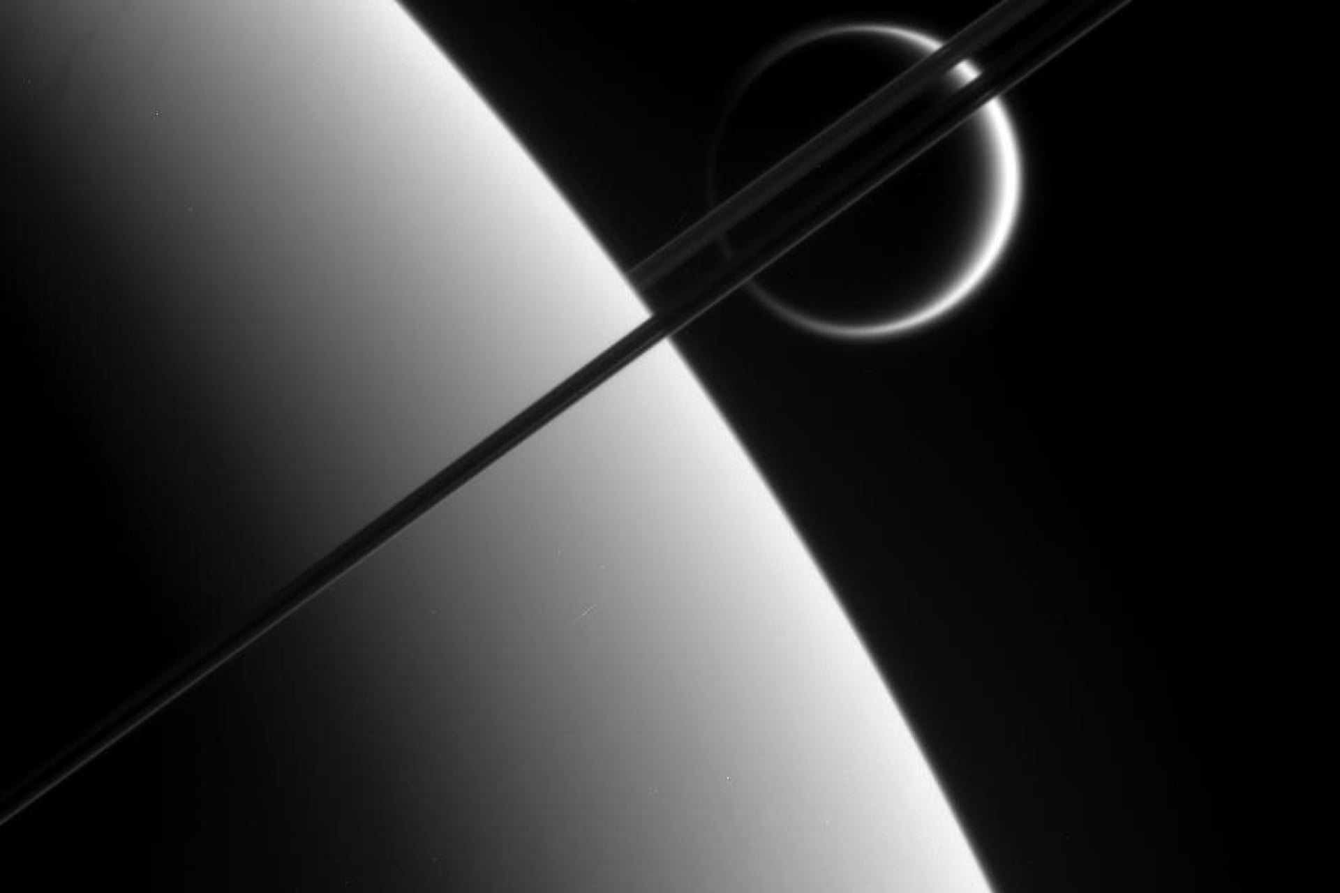 Titan lying beyond Saturn, captured by NASA's Cassini spacecraft.