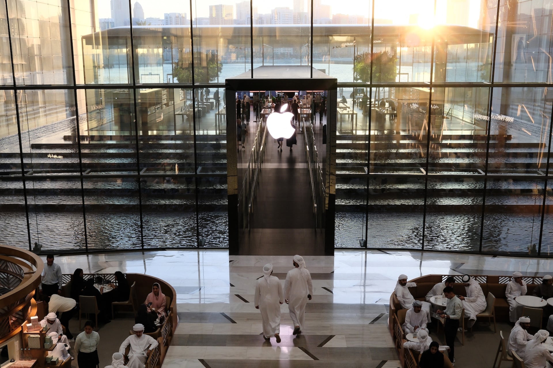 People sit in a cafe outside an Apple Store in the UAE on May 8, 2025.  