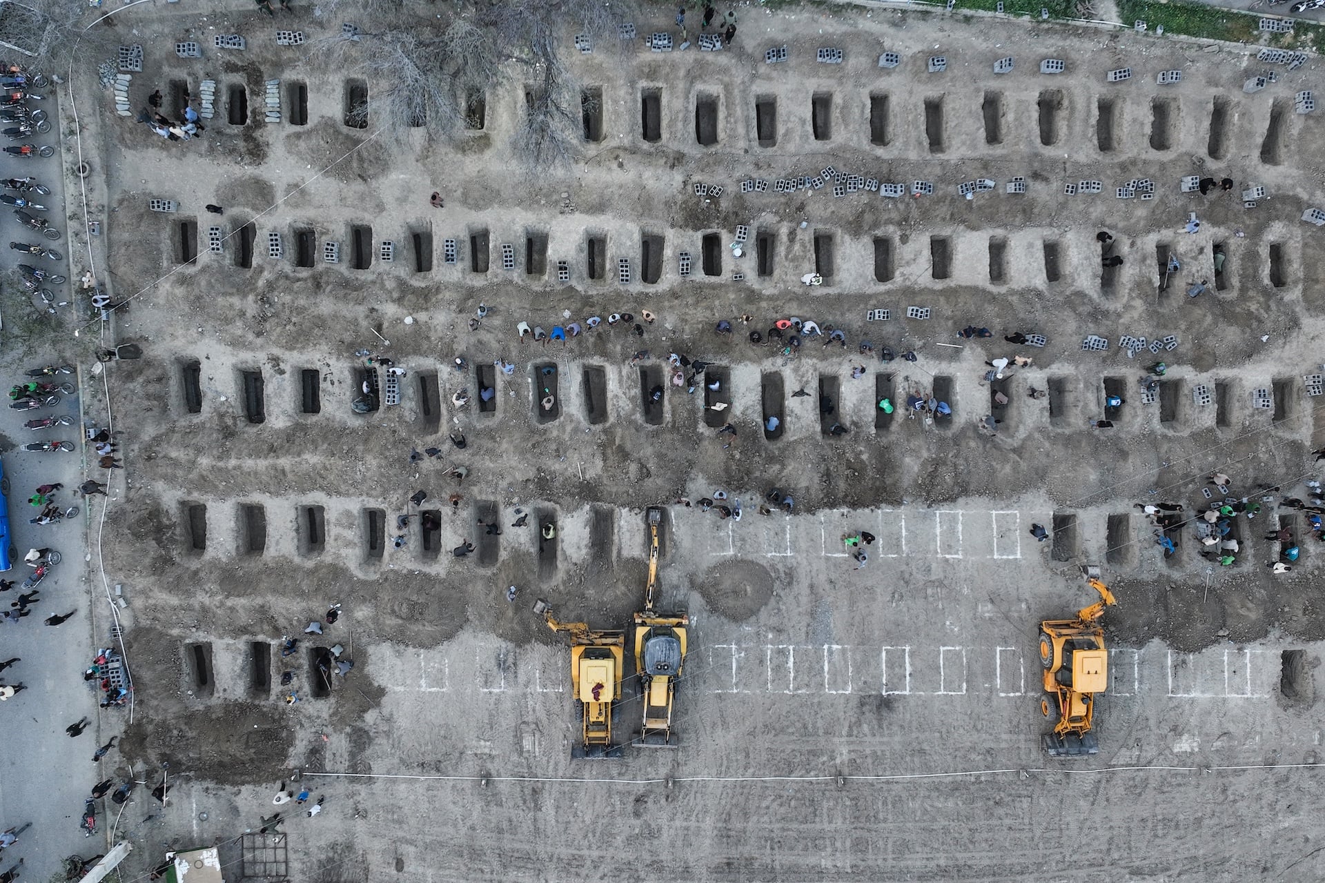 In this aerial handout picture released by the Iranian Press Center, mourners dig graves during the funeral for children killed in a reported strike on a primary school in Iran's Hormozgan province in Minab on March 3, 2026. 