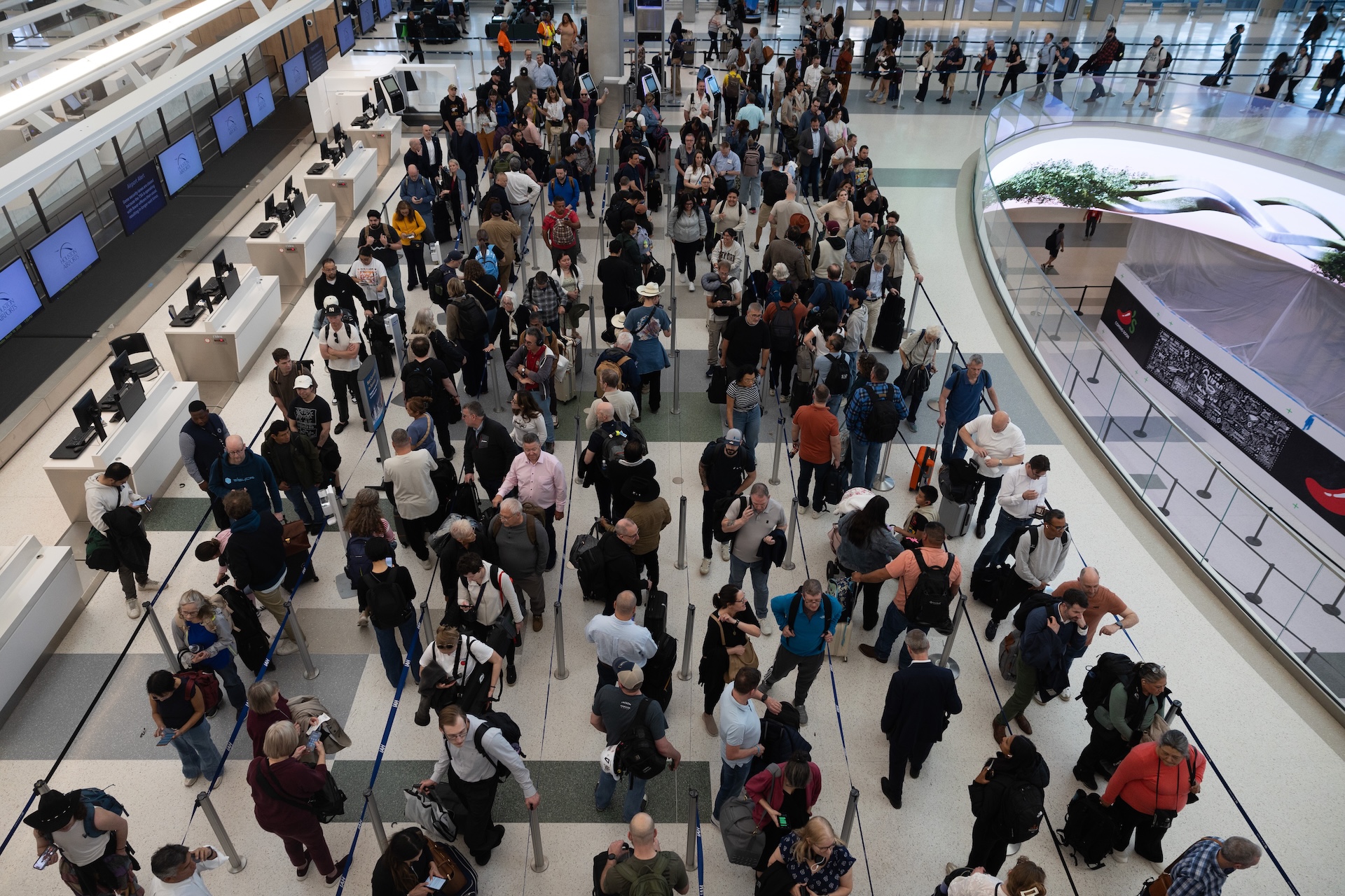 Travelers wait in line at Terminal E at George Bush International Airport on March 19, 2026 in Houston, Texas. 