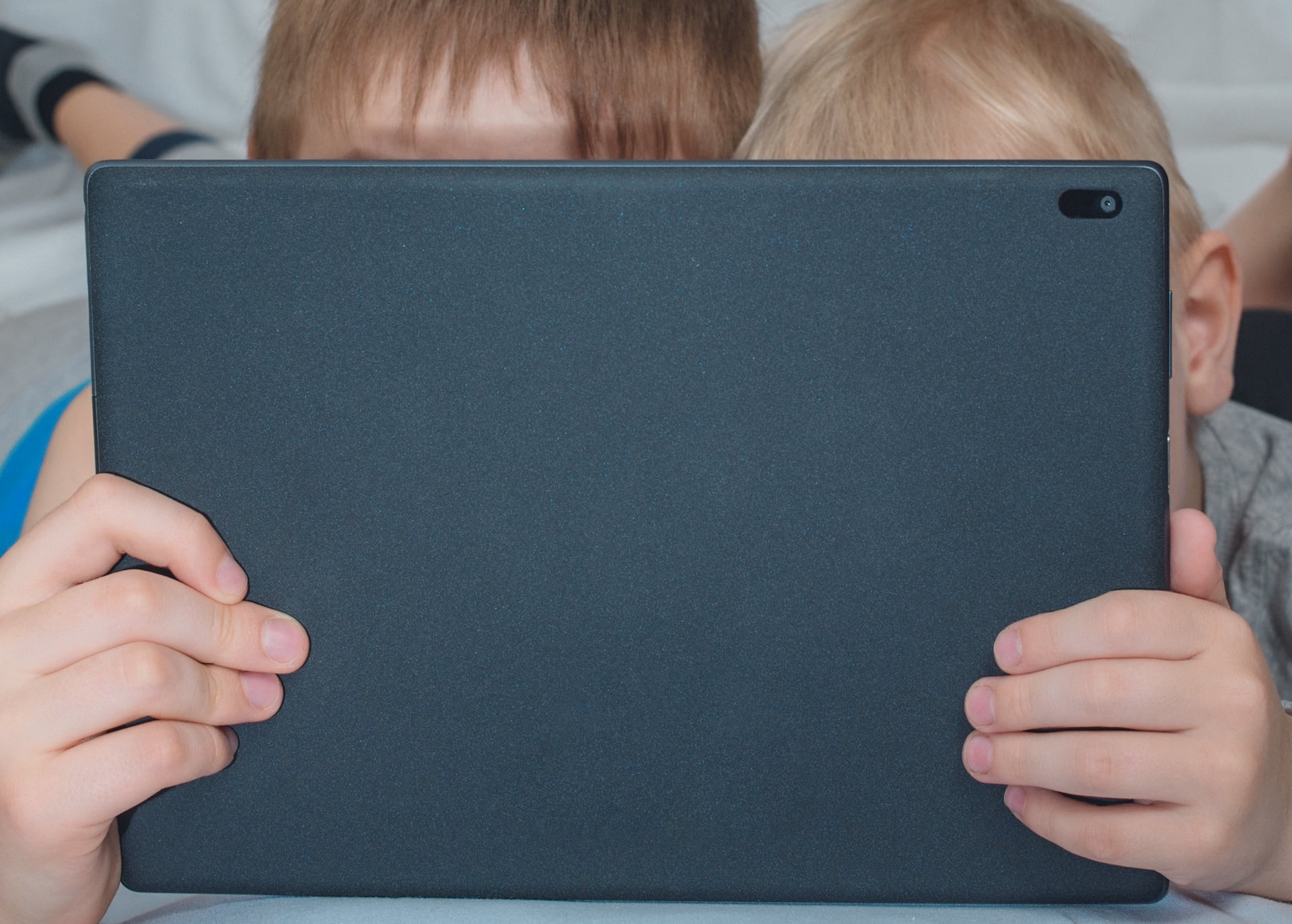 Stock photo of kids consuming content on a tablet