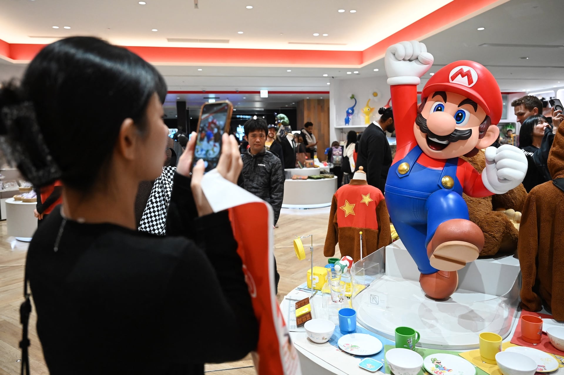 A woman takes photos of a Super Mario figure at the Nintendo Tokyo store in Tokyo on November 4, 2025. (Photo by GREG BAKER / AFP) (Photo by GREG BAKER/AFP via Getty Images)