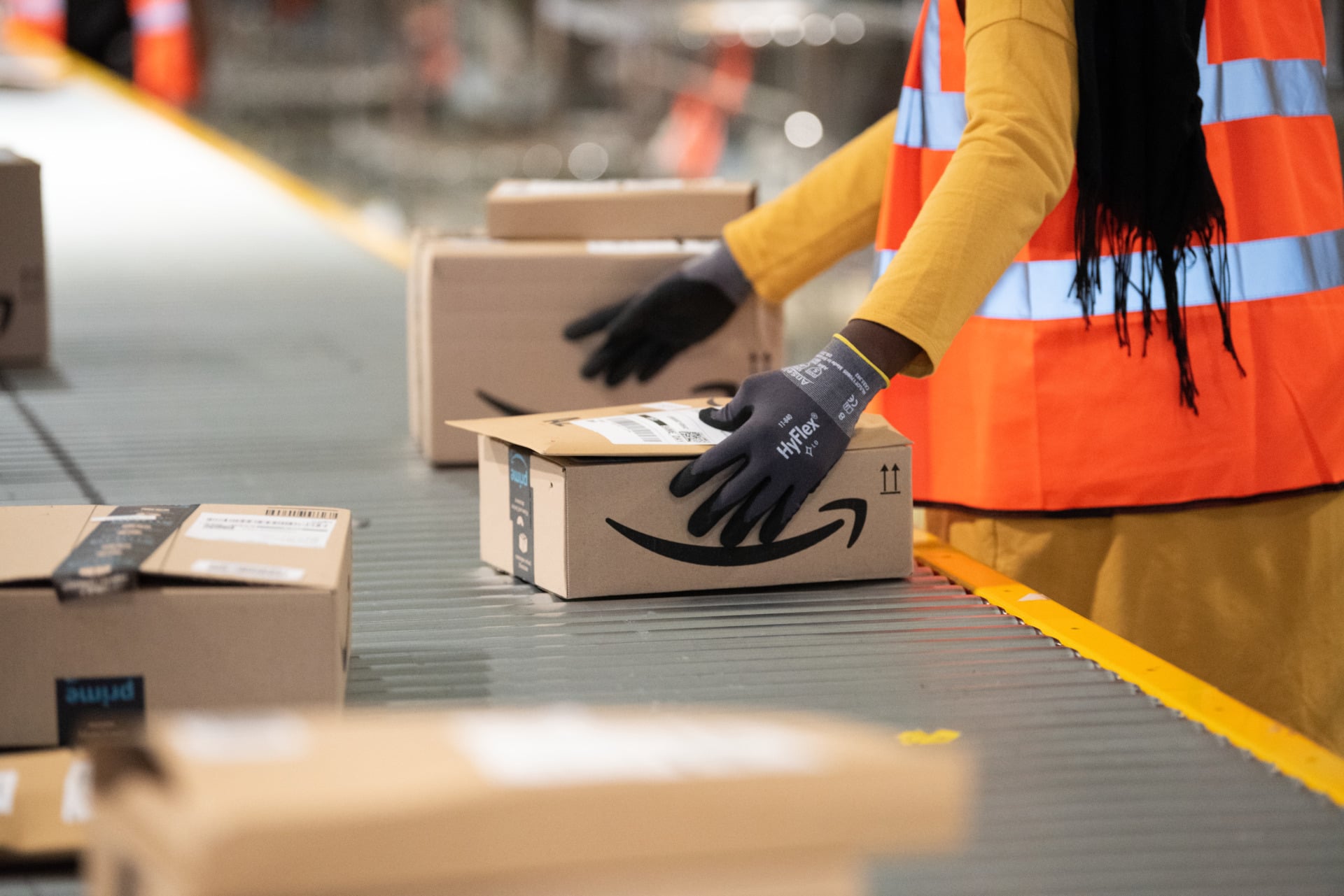 Amazon warehoue worker handling a package with the Amazon logo on it
