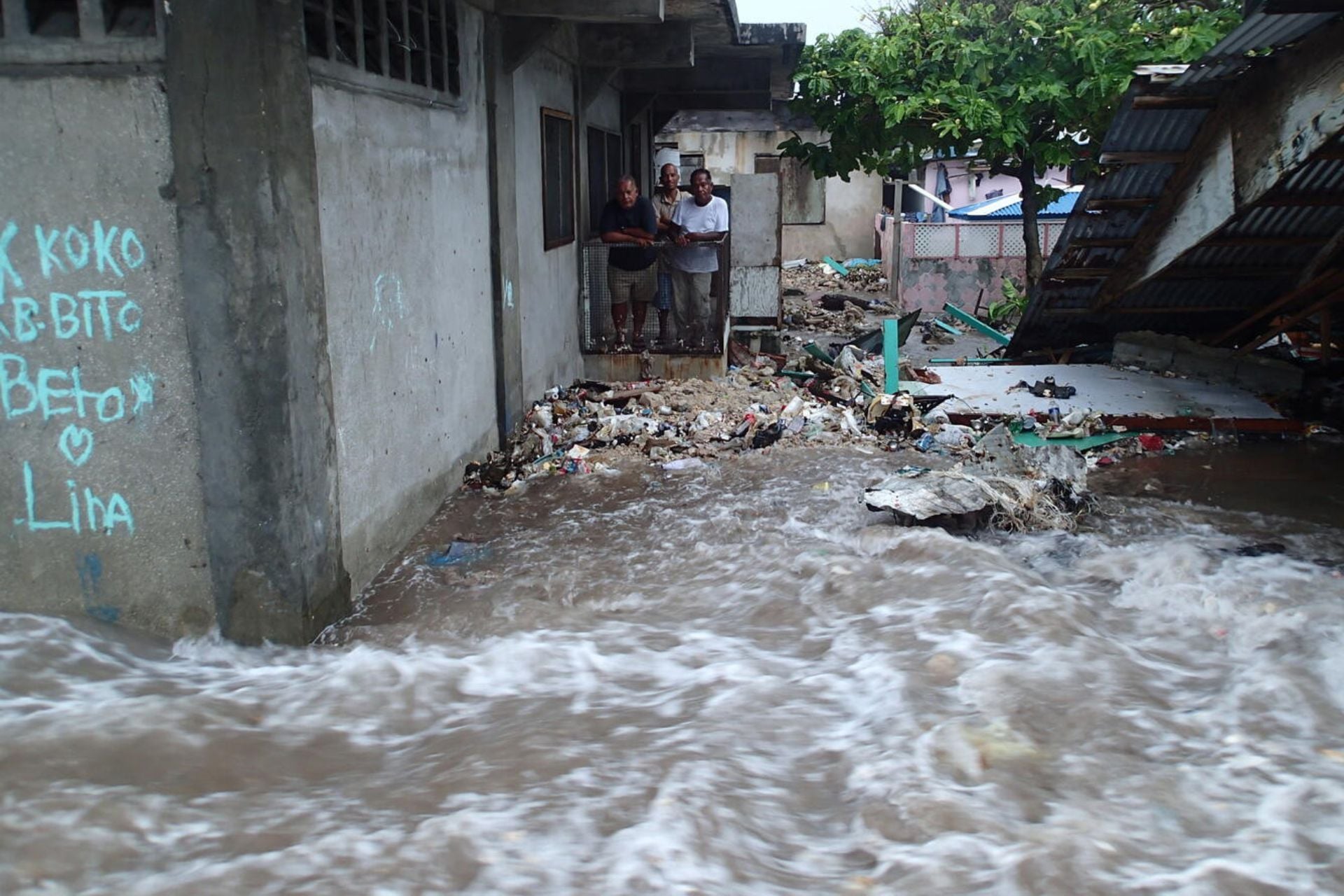 Residents of northern Majuro in the Marshall Islands watch their neighborhood flood with seawater during a king tide in March 2014