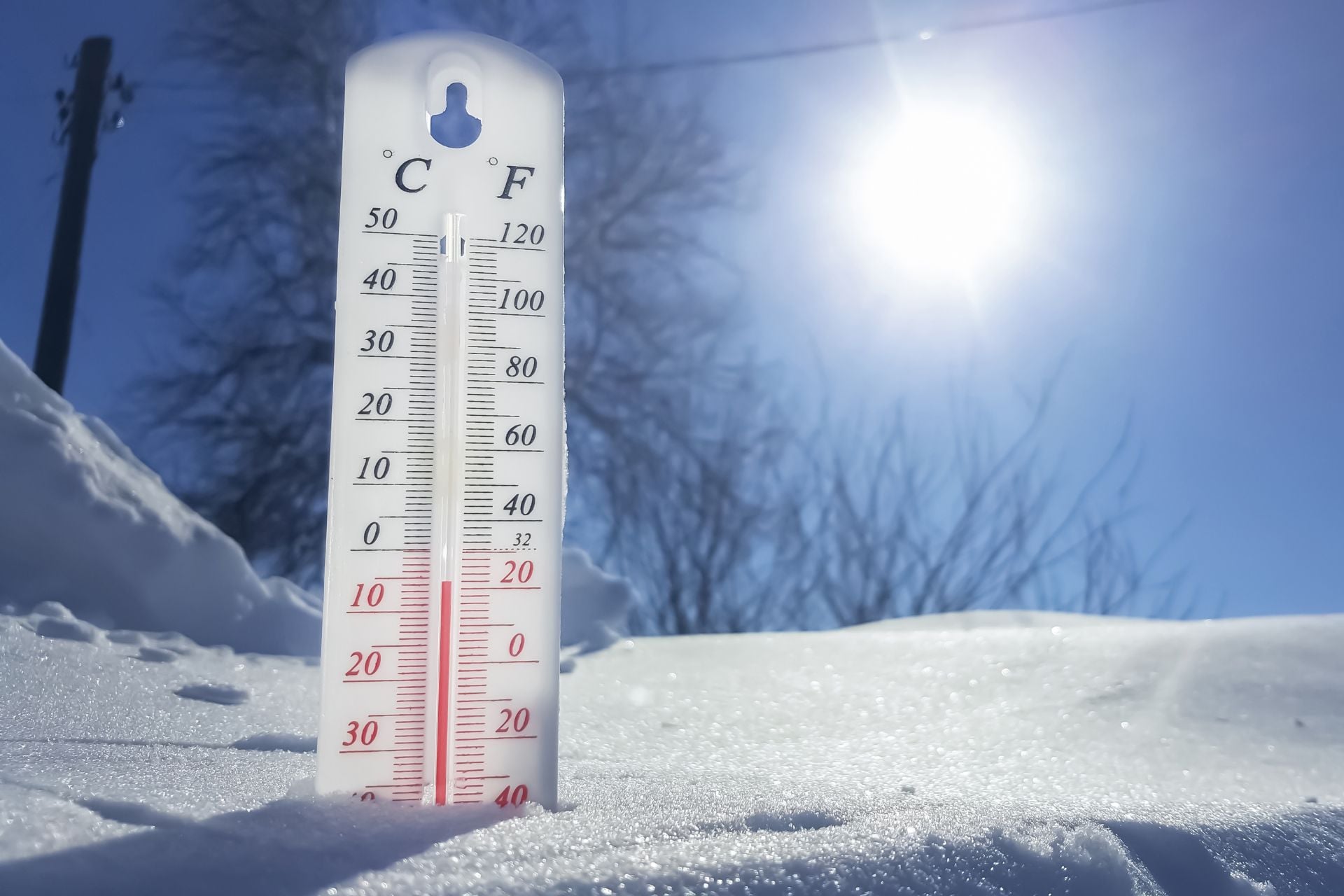 An outdoor thermometer stuck in the snow displays chilly temperatures 