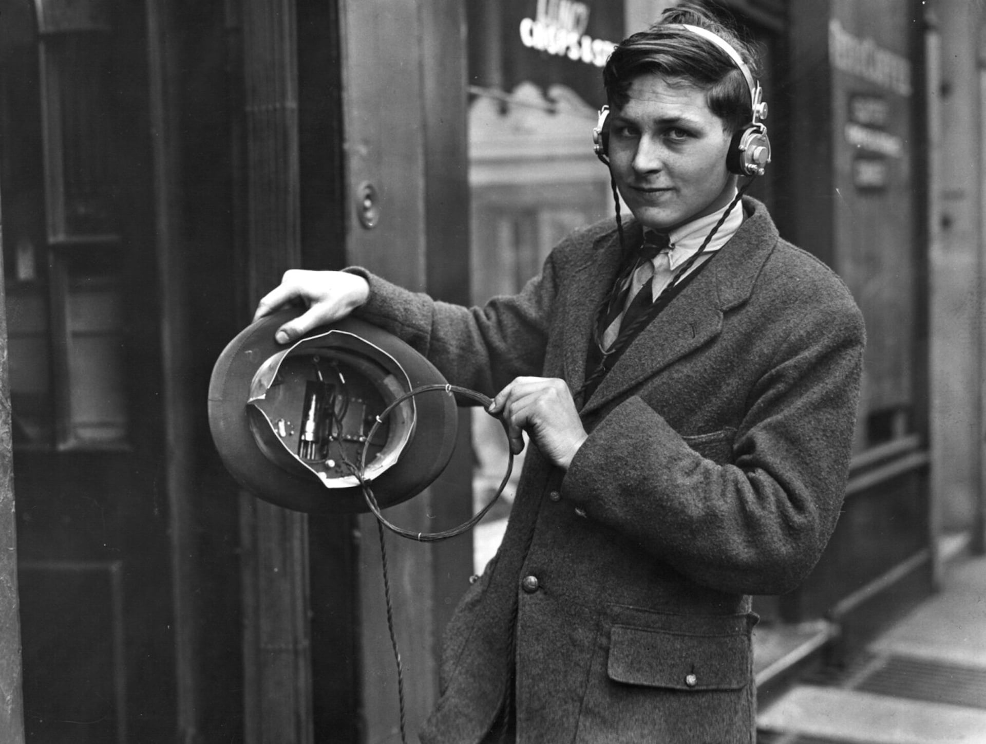 Eighteen year old inventor, H Day wearing headphones attached to a wireless under his top hat in May 1922.