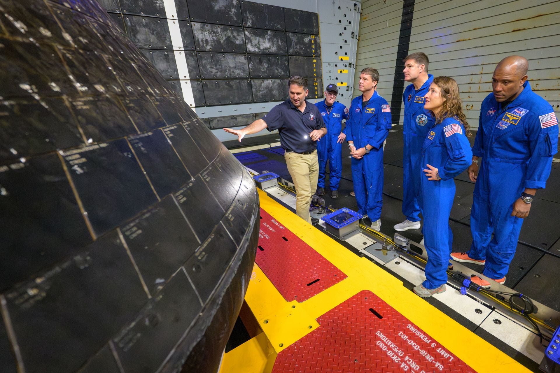 NASA’s acting Orion vehicle integration manager Luis Saucedo (left) inspects the Orion capsule with NASA flight surgeon Richard Scheuring and Artemis 2 astronauts Reid Wiseman, Jeremy Hansen, Christina Koch, and Victor Glover aboard the USS John P. Murtha on Saturday, April 11, 2026