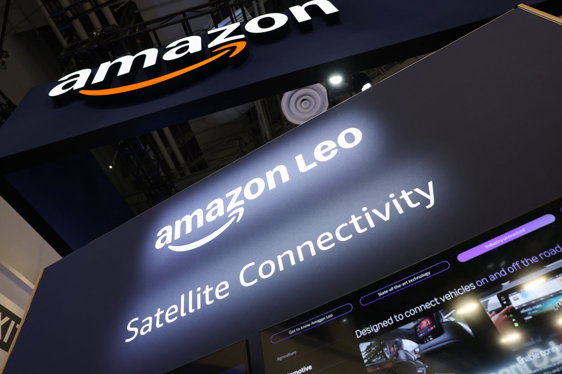 A lit up sign reads "Amazon Leo" and under it "Satellite Connectivity."