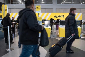 Passengers at an airport rushing past the Spirit check in desk