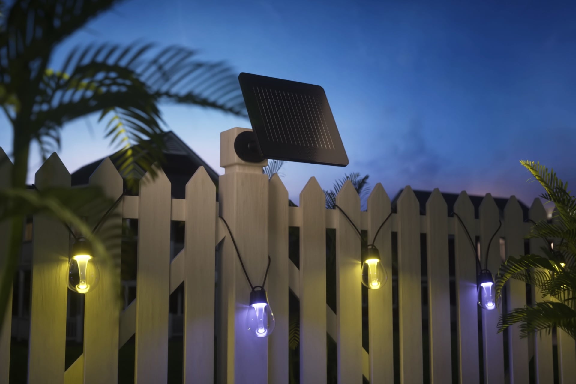 Govee Outdoor Solar String Lights hanging on a fence with a solar panel attached to the fence post.
