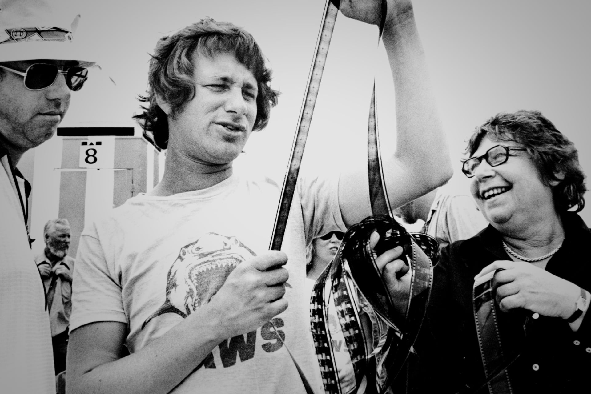 Steven Spielberg looks at a film strip with crew on the set of 'Jaws,' as seen in the documentary 'Jaws @ 50: The Definitive Inside Story.'
