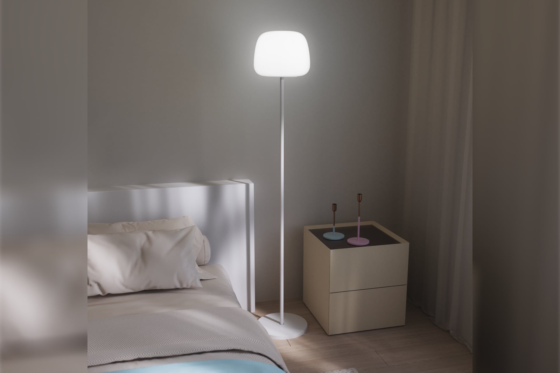 The Lantern Floor Lamp pictured in full, standing next to a bed.